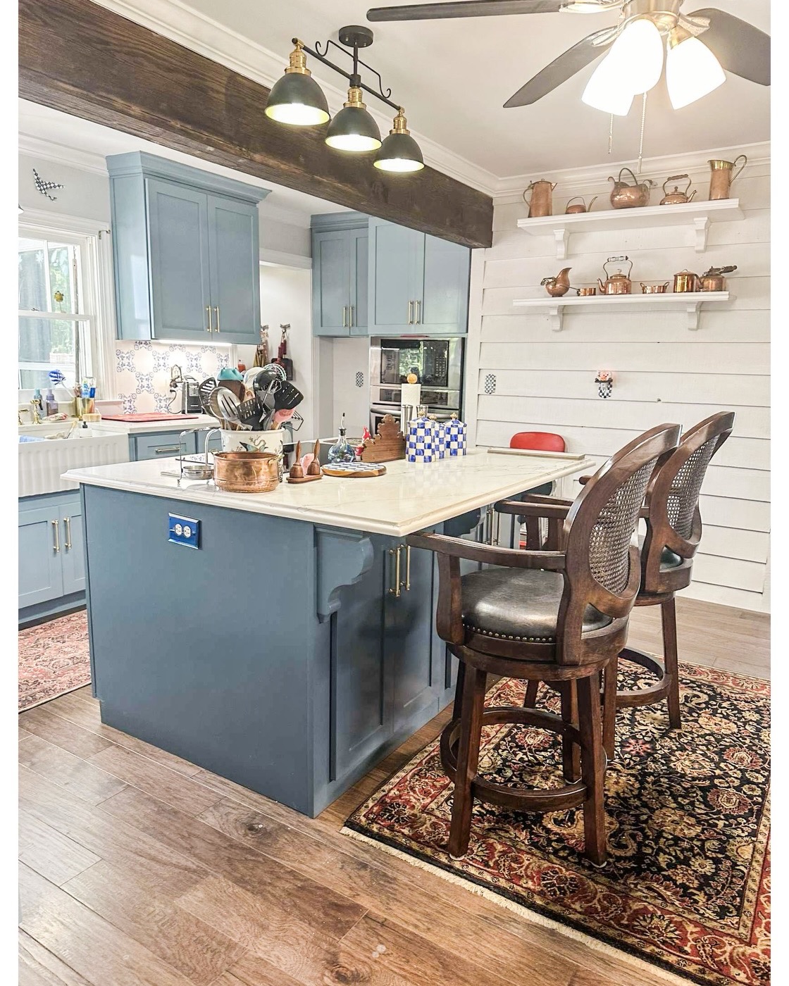 Blue custom kitchen island with brass hardware in a North Georgia home