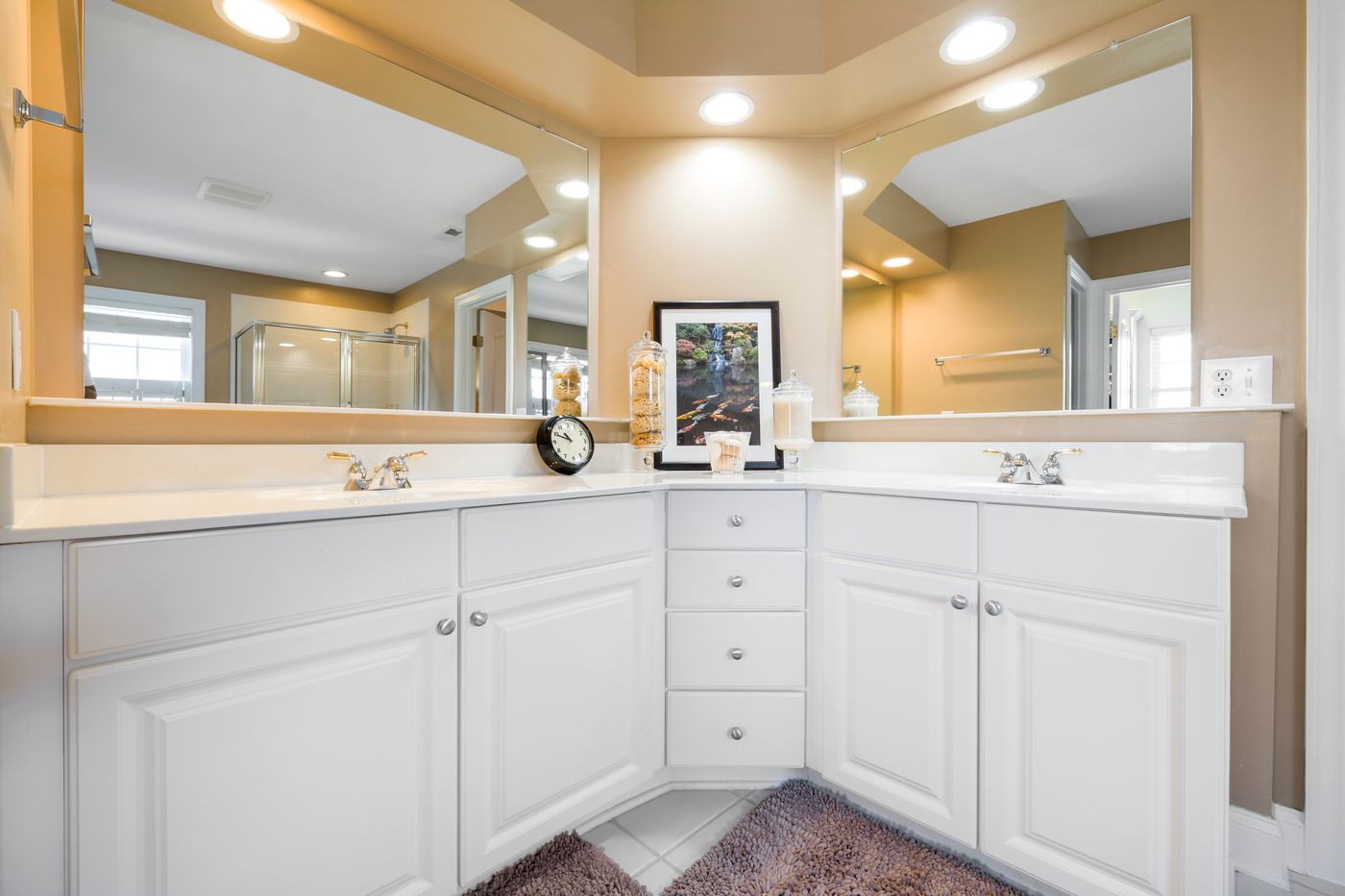 Bathroom vanity cabinetry with drawers, doors, mirror, and white countertop