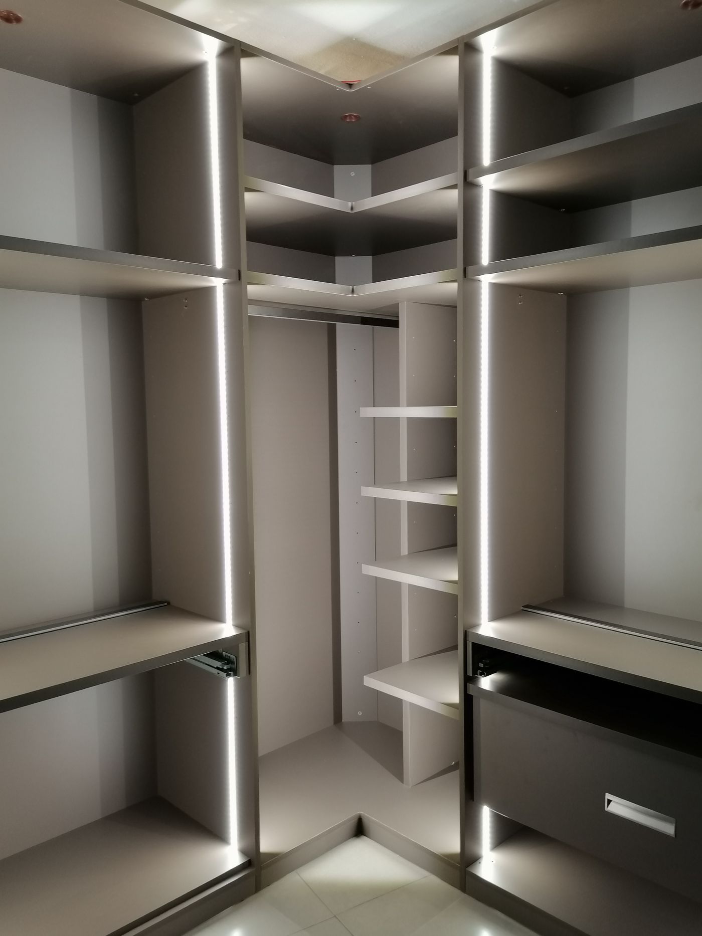Walk-in closet storage with open shelves, drawers, and hanging space
